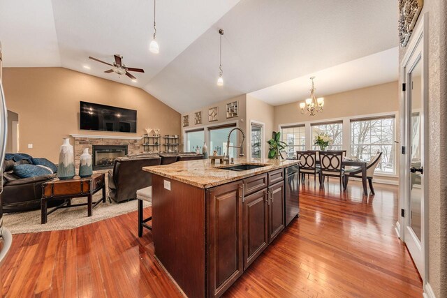 W209N11385 Reger Ct, Germantown, WI 53022 - kitchen with dishwasher, a sink, hardwood / wood-style flooring, a fireplace, and vaulted ceiling