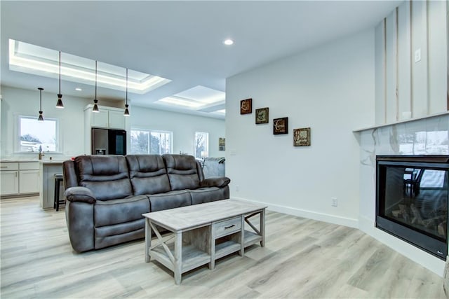 2480 116th St, Chippewa Falls, WI 54729 - living room featuring recessed lighting, a raised ceiling, a premium fireplace, and light wood-style floors