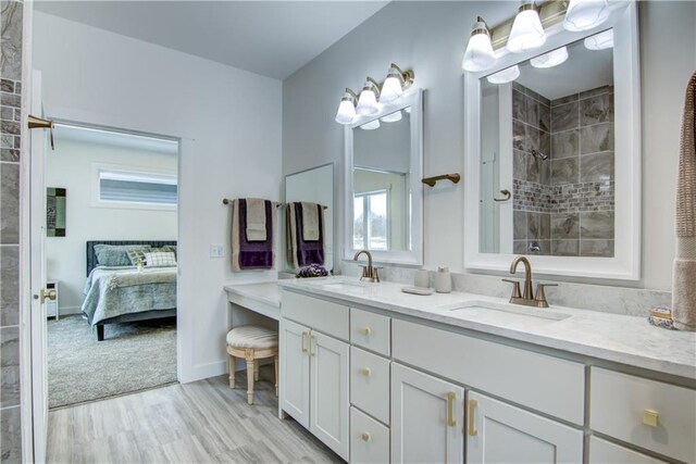 2480 116th St, Chippewa Falls, WI 54729 - ensuite bathroom featuring double vanity, a tile shower, a sink, and wood finished floors