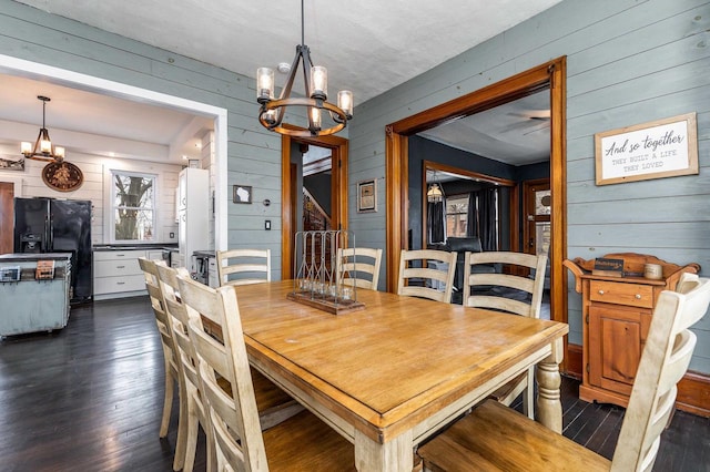 158 E Water St, Shullsburg, WI 53586 - dining space featuring dark wood-type flooring, wooden walls, and an inviting chandelier