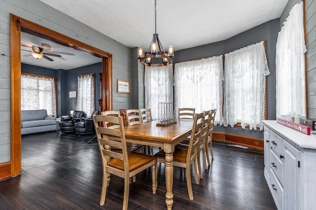 158 E Water St, Shullsburg, WI 53586 - dining room with wood walls, dark wood-type flooring, and ceiling fan with notable chandelier