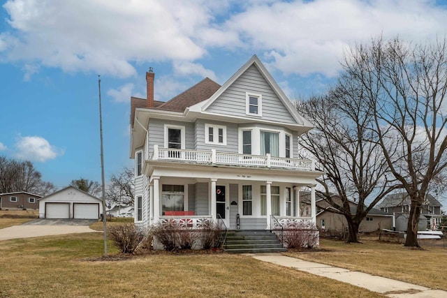 158 E Water St, Shullsburg, WI 53586 - view of front of house featuring a balcony, an outdoor structure, a detached garage, a front lawn, and covered porch