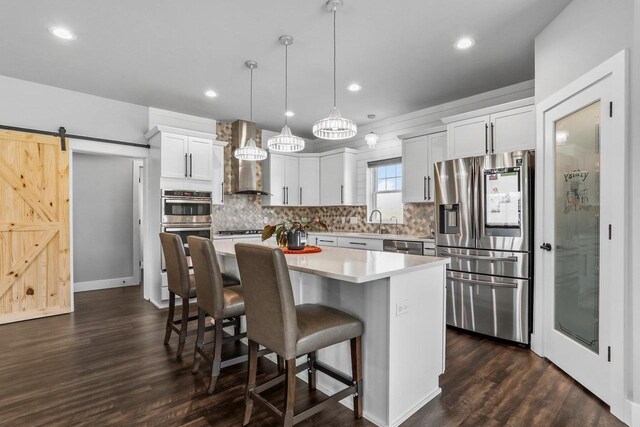 3102 Hope St, Sun Prairie, WI 53590 - kitchen with white cabinetry, a breakfast bar, a kitchen island, appliances with stainless steel finishes, and backsplash