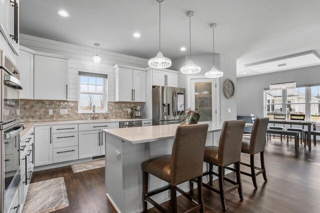3102 Hope St, Sun Prairie, WI 53590 - kitchen with a breakfast bar area, light countertops, decorative backsplash, and stainless steel appliances