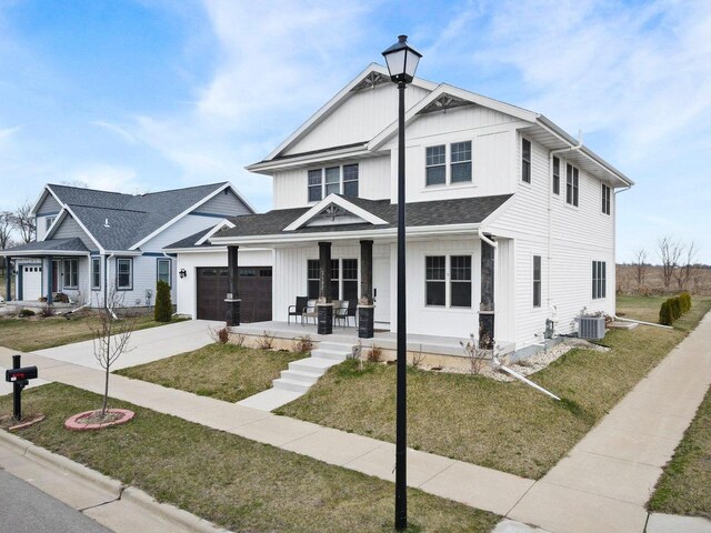 3102 Hope St, Sun Prairie, WI 53590 - view of front of home with driveway, a front yard, a porch, central AC unit, and a garage