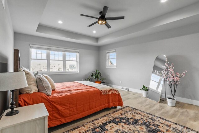 3102 Hope St, Sun Prairie, WI 53590 - bedroom featuring visible vents, baseboards, a raised ceiling, light wood-style floors, and recessed lighting