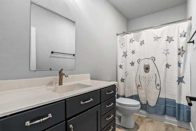 3102 Hope St, Sun Prairie, WI 53590 - bathroom with toilet, wood finished floors, vanity, and shower / bath combo with shower curtain