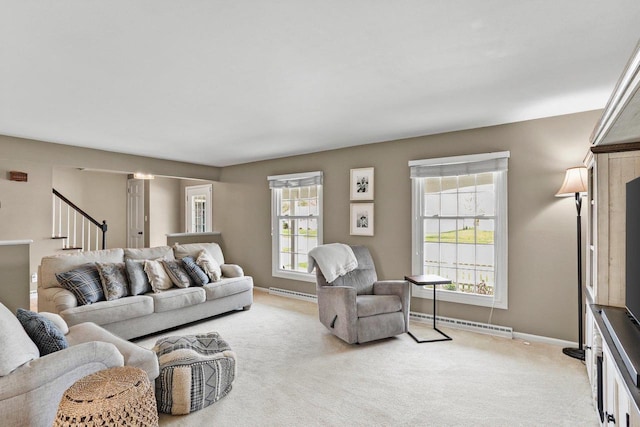 living room featuring baseboards, light carpet, baseboard heating, and a baseboard radiator