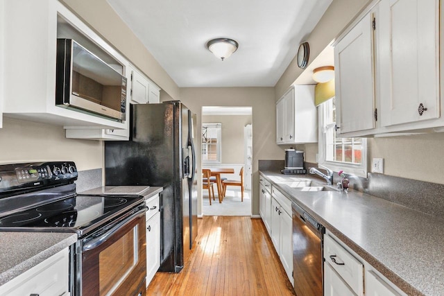 kitchen featuring a sink, white cabinetry, appliances with stainless steel finishes, and light wood-style flooring