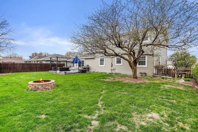 view of yard with fence, a fire pit, and a deck
