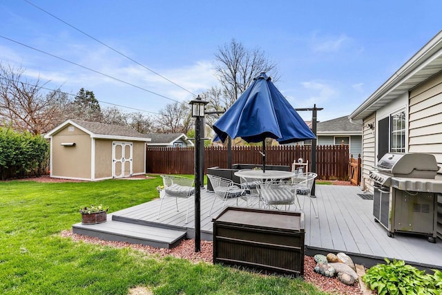 wooden deck featuring outdoor dining space, a shed, a fenced backyard, an outdoor structure, and a grill