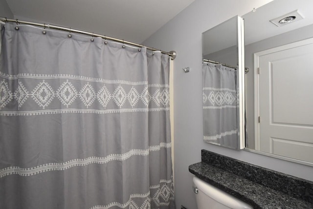 full bathroom featuring toilet and visible vents