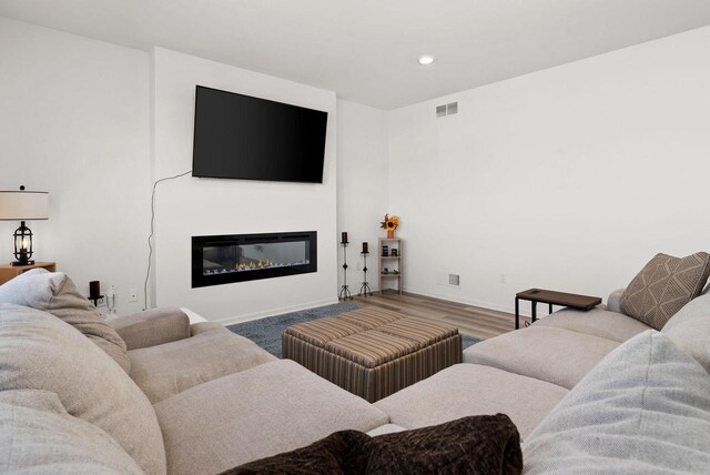 708 Narvik Cir, Stoughton, WI 53589 - living room with a glass covered fireplace, baseboards, recessed lighting, visible vents, and wood finished floors