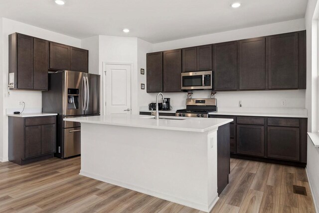 708 Narvik Cir, Stoughton, WI 53589 - kitchen with stainless steel appliances, dark brown cabinetry, light wood-style flooring, and a sink