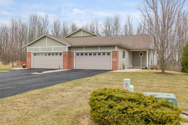 ranch-style house featuring brick siding, driveway, an attached garage, and a front lawn