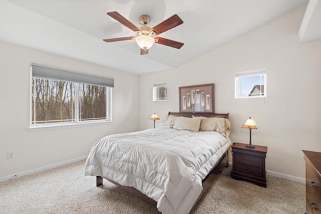 bedroom featuring vaulted ceiling, baseboards, multiple windows, and carpet