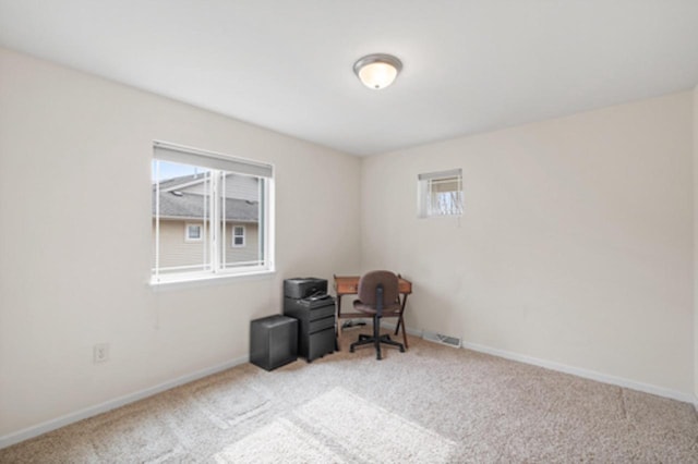 office featuring a wealth of natural light, carpet flooring, visible vents, and baseboards