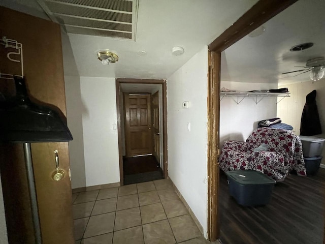 hallway featuring visible vents, baseboards, and tile patterned flooring