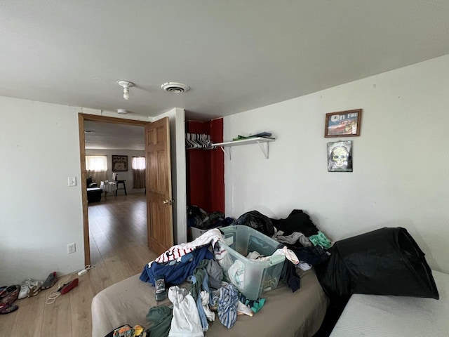 bedroom featuring visible vents, a closet, and wood finished floors