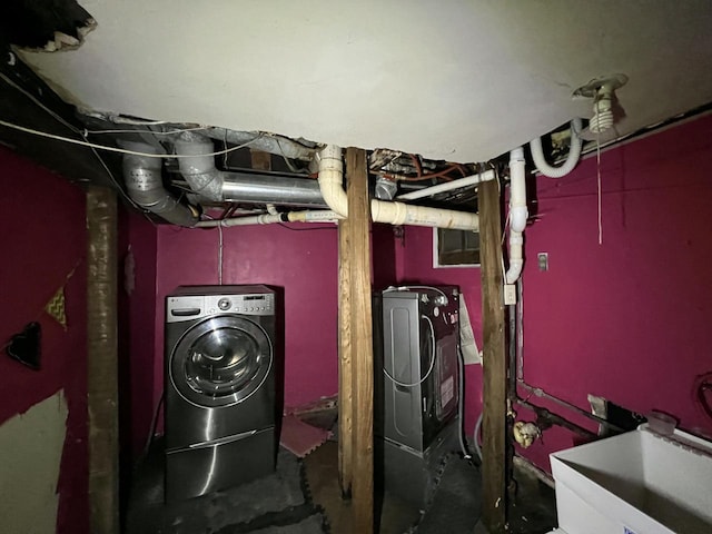 clothes washing area with laundry area, washing machine and clothes dryer, and a sink