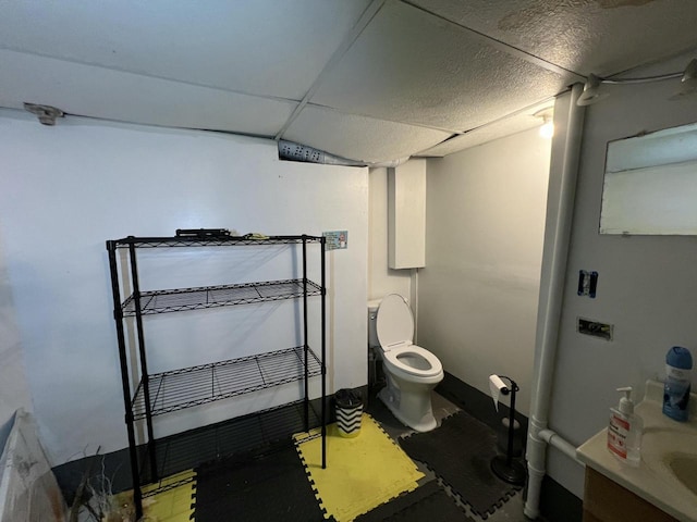 bathroom featuring toilet and a drop ceiling