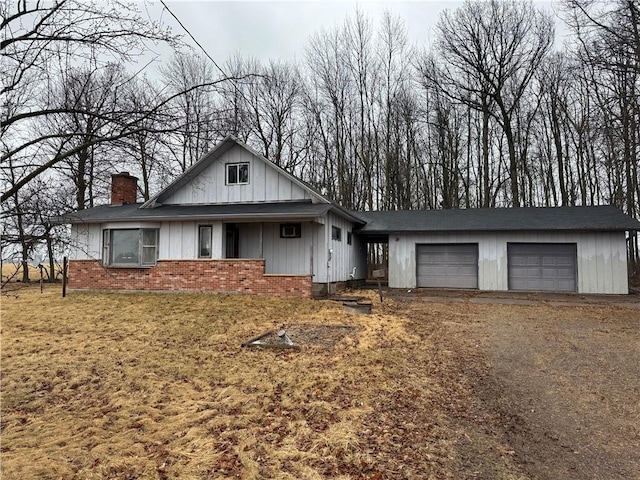 W5588 US Highway 8, Tony, WI 54563 - view of front of home featuring brick siding, board and batten siding, a chimney, and an attached garage
