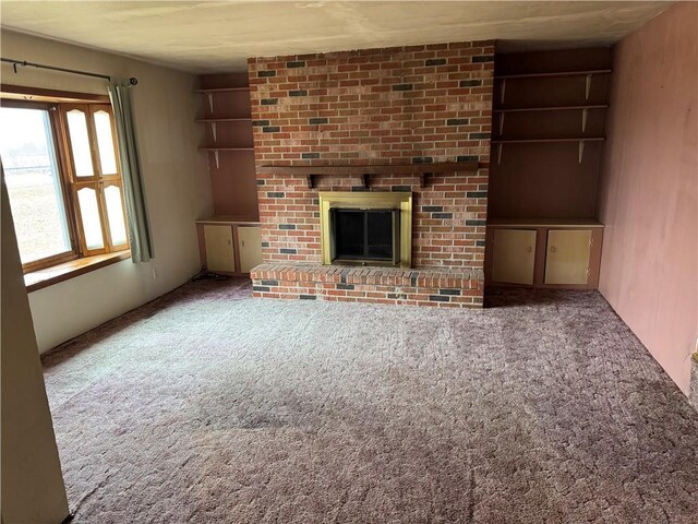 W5588 US Highway 8, Tony, WI 54563 - unfurnished living room with a brick fireplace and carpet