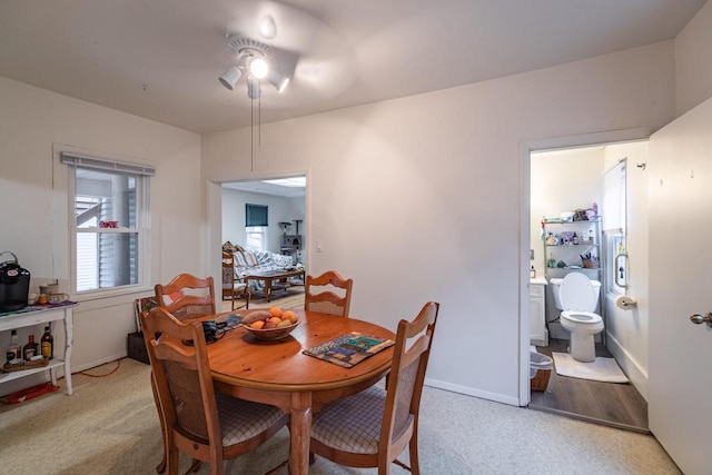 dining area with light colored carpet, baseboards, and a ceiling fan