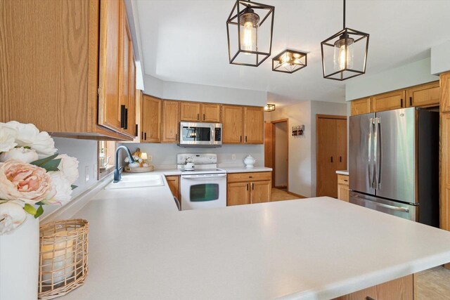 178 Weybridge Dr, Sun Prairie, WI 53590 - kitchen with stainless steel appliances, a sink, light countertops, a peninsula, and hanging light fixtures