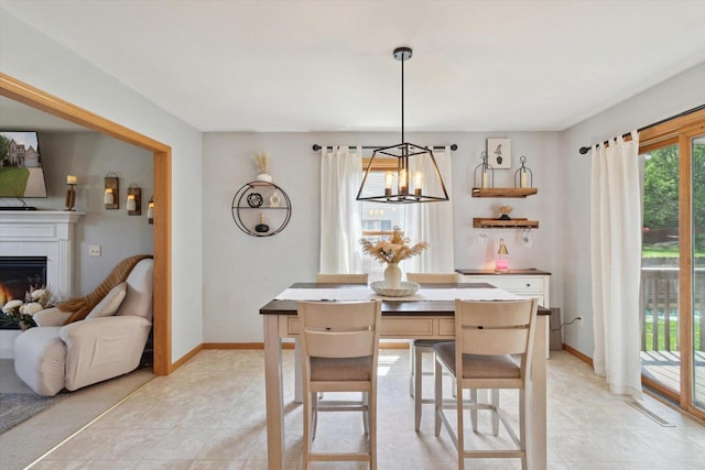 178 Weybridge Dr, Sun Prairie, WI 53590 - dining space with a chandelier, a fireplace, light tile patterned flooring, and baseboards