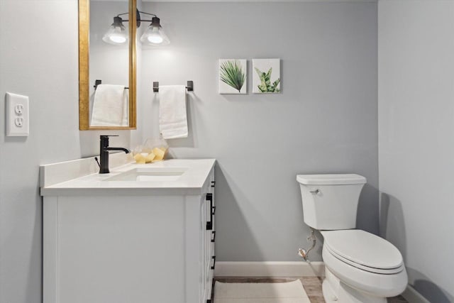 178 Weybridge Dr, Sun Prairie, WI 53590 - half bath featuring toilet, vanity, baseboards, and wood finished floors