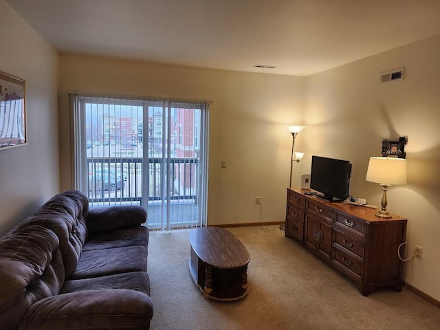 living room with light carpet, visible vents, and baseboards