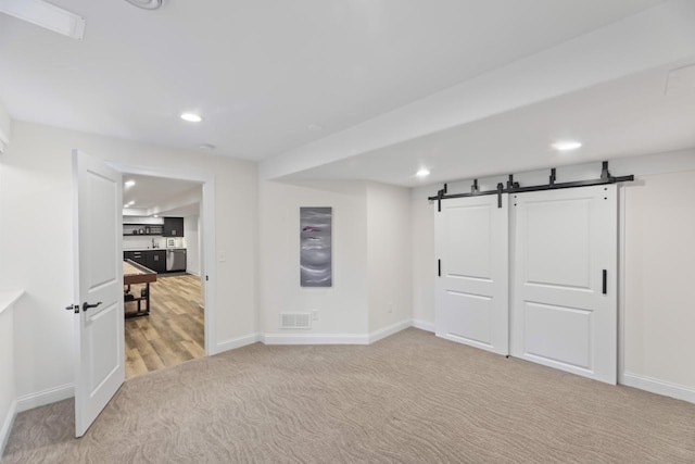 W246N1979 Still River Dr, Pewaukee, WI 53072 - basement with visible vents, baseboards, a barn door, recessed lighting, and light carpet