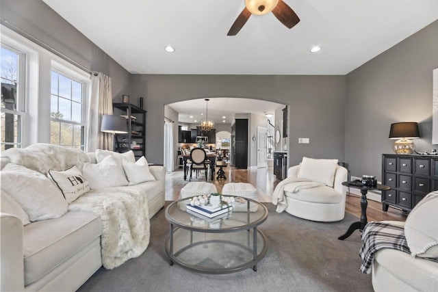 W246N1979 Still River Dr, Pewaukee, WI 53072 - living room featuring recessed lighting, arched walkways, wood finished floors, and ceiling fan with notable chandelier