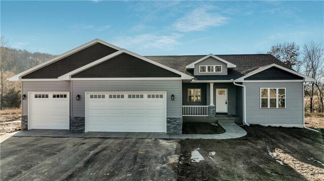 LOT3 510th Ave, Menomonie, WI 54751 - craftsman-style house featuring aphalt driveway, stone siding, an attached garage, and covered porch
