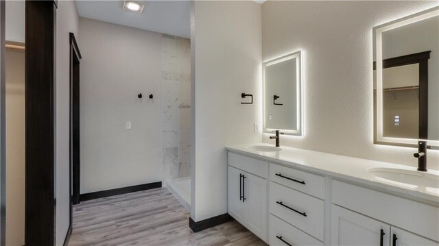 LOT3 510th Ave, Menomonie, WI 54751 - bathroom with a sink, a tile shower, double vanity, and wood finished floors