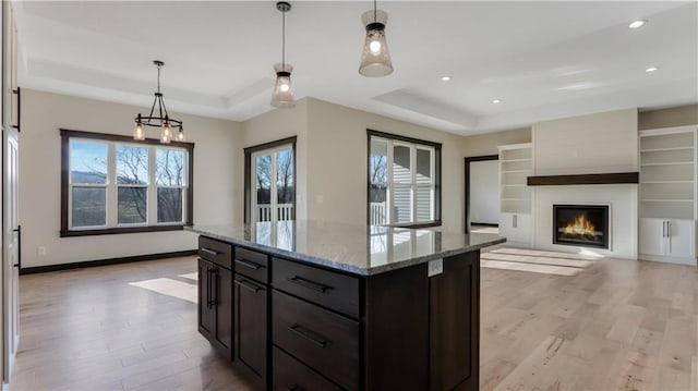 LOT3 510th Ave, Menomonie, WI 54751 - kitchen featuring light wood-style floors, a center island, light stone counters, and a raised ceiling