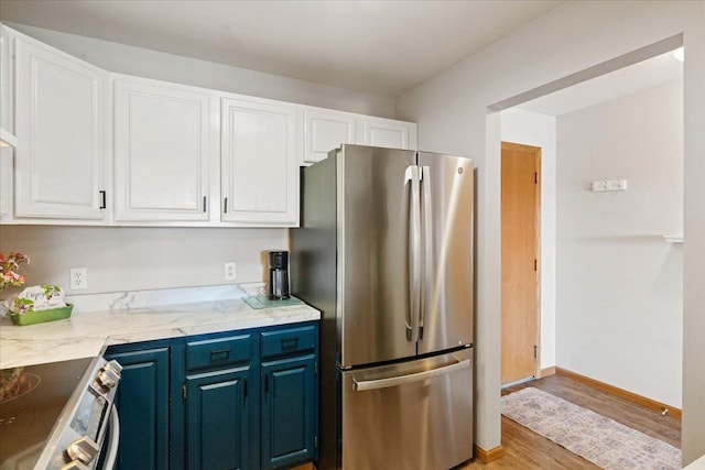 kitchen featuring white cabinetry, stainless steel appliances, and light wood finished floors