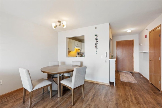 dining space with wood finished floors, baseboards, and a notable chandelier