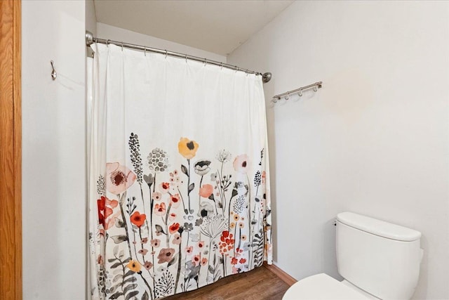 full bathroom featuring toilet, a shower with shower curtain, and wood finished floors
