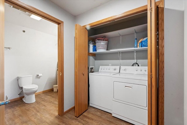 laundry area with independent washer and dryer, light wood-style floors, baseboards, and laundry area