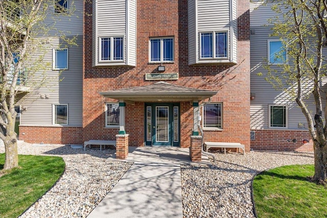 view of exterior entry with brick siding