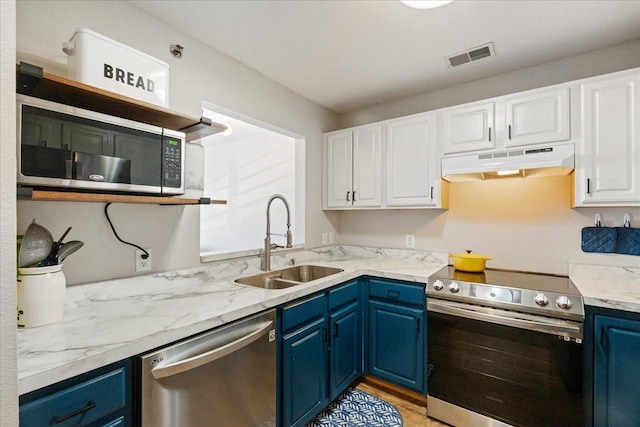 kitchen featuring a sink, white cabinets, appliances with stainless steel finishes, blue cabinetry, and under cabinet range hood