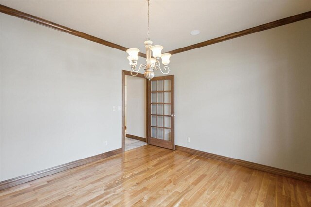 1716 Symphony Hts, Green Bay, WI 54311 - unfurnished room with crown molding, baseboards, a notable chandelier, and light wood-style floors
