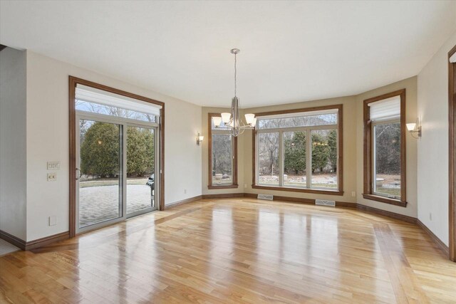 1716 Symphony Hts, Green Bay, WI 54311 - unfurnished dining area featuring visible vents, baseboards, light wood finished floors, and a notable chandelier