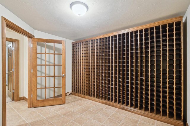 1716 Symphony Hts, Green Bay, WI 54311 - wine area with baseboards, tile patterned flooring, lofted ceiling, and a textured ceiling