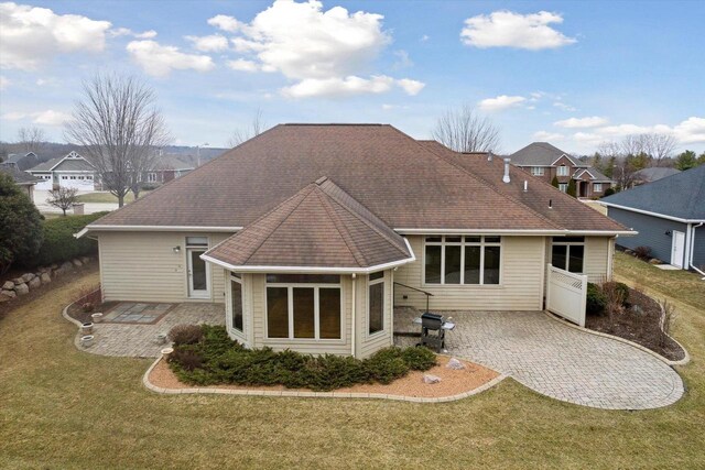 1716 Symphony Hts, Green Bay, WI 54311 - back of house with a yard, a residential view, a shingled roof, and a patio