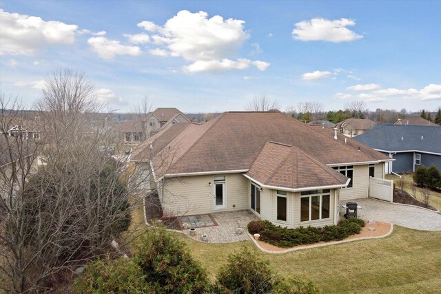 1716 Symphony Hts, Green Bay, WI 54311 - back of house with a yard, a residential view, a shingled roof, and a patio