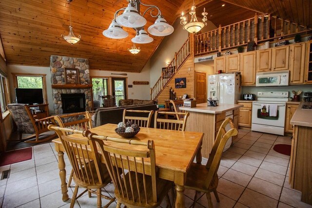 6009 W Dobbert Rd, Winter, WI 54896 - dining space with high vaulted ceiling, a fireplace, stairway, wood ceiling, and light tile patterned flooring