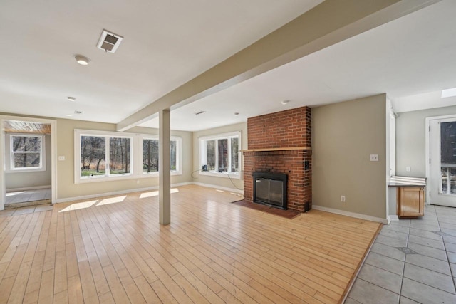 149 Oakwood Ave, Edgerton, WI 53534 - unfurnished living room with visible vents, baseboards, light wood finished floors, and a fireplace